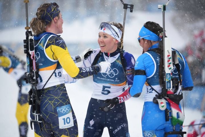 Elvira Oeberg, de Suède, félicite Océane Michelon, de France, après sa victoire au biathlon féminin de 12,5 kilomètres en départ groupé aux Jeux olympiques d'hiver de 2026 à Anterselva, en Italie, le samedi 21 février 2026. (AP Photo/Andrew Medichini)