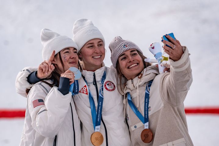La médaillée d'or Elizabeth Lemley (C) des États-Unis, la médaillée d'argent Jaelin Kauf (L) des États-Unis et la médaillée de bronze Perrine Laffont, de France, prennent un selfie lors de la cérémonie de remise des prix après la finale des bosses féminines de ski acrobatique aux Jeux olympiques d'hiver de Milan-Cortina 2026 à Livigno, en Italie.