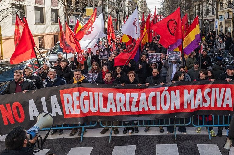 Des manifestants brandissent une banderole sur laquelle on peut lire « Non à la régularisation massive » lors d'une manifestation contre une régularisation massive des migrants devant le siège du Parti socialiste ouvrier espagnol (PSOE).