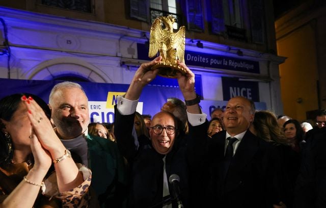 Le candidat de l’Union de la droite et du Rassemblement national à la mairie de Nice Éric Ciotti tient un aigle couronné, symbole de la ville de Nice après sa victoire aux municipales, le 22 mars, 2026.
