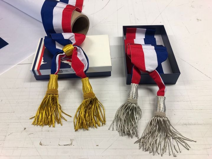 Sur les écharpes, le gland est doré pour les maires et argenté pour les adjoints.