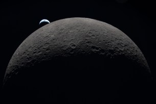 art002e009287 (6 avril 2026) – La Terre se couche à 18h41 EDT, le 6 avril 2026, au-dessus du bord courbé de la Lune dans cette photo capturée par l'équipage d'Artemis II alors qu'ils voyageaient autour de la face éloignée de la Lune. Le bassin Orientale se situe au bord de la surface lunaire visible. Le bassin Hertzsprung apparaît comme deux anneaux concentriques subtils, interrompus par Vavilov, un cratère plus jeune superposé à la structure plus ancienne. Les lignes d'indentations sont des chaînes de cratères secondaires formées par les débris éjectés par l'énorme impact qui a créé Orientale. La partie sombre de la Terre est en pleine nuit, tandis que sur le côté de jour de la Terre, des nuages tourbillonnants sont visibles au-dessus de l'Australie et de la région Océanie.