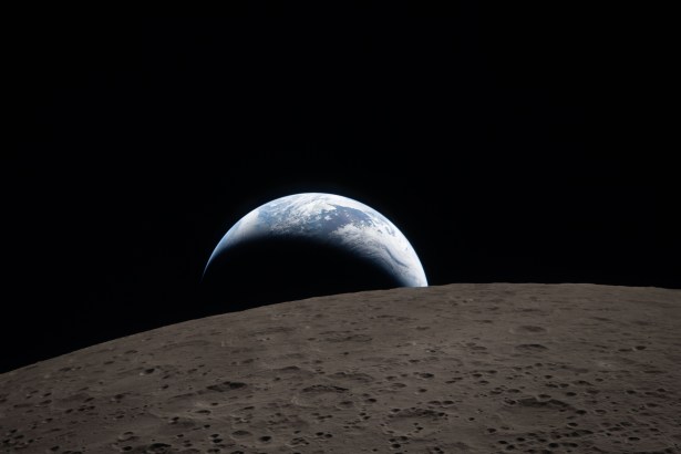 art002e009288 (6 avril 2026) – Coucher de Terre capturé à travers la fenêtre du vaisseau Orion à 18h41 EDT, le 6 avril 2026, pendant le survol de la Lune par l'équipage d'Artemis II. Une Terre bleue atténuée avec des nuages blancs brillants se couche derrière la surface lunaire cratérisée. La partie sombre de la Terre est en pleine nuit. Sur le côté jour de la Terre, des nuages tourbillonnants sont visibles au-dessus de l'Australie et de la région Océanie. Au premier plan, le cratère Ohm a des bords en terrasses et un sol plat interrompu par des sommets centraux. Les sommets centraux se forment dans les cratères complexes lorsque la surface lunaire, liquéfiée lors de l'impact, éclabousse vers le haut lors de la formation du cratère.