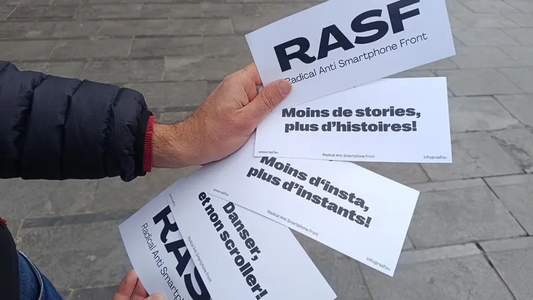 Le militant allemand montre ses affichettes aux slogans variés
