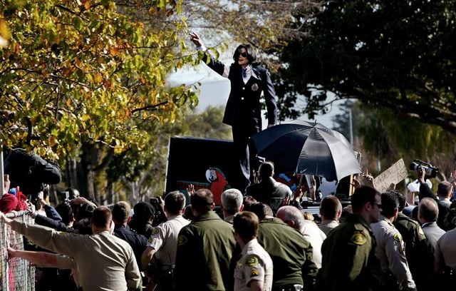 Michael Jackson salue ses fans sur le toit de sa limousine après sa mise en accusation pour agression sexuelle.