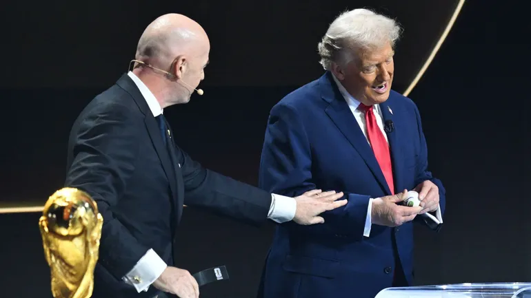 Le président américain Donald Trump tire un carton aux côtés du président italien de la FIFA, Gianni Infantino, lors du tirage au sort de la Coupe du monde de football 2026, qui se déroulera aux États-Unis, au Canada et au Mexique.