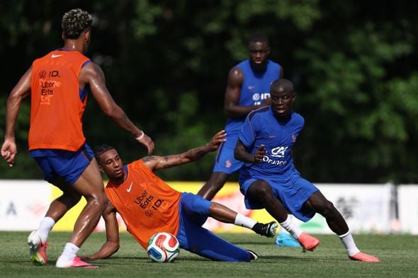 Le milieu de terrain français #13 N'Golo Kante (R) et l'attaquant français #11 Michael Olise (C) participent à une séance d'entraînement à l'université de Bentley, le camp de base de l'équipe, lors de la Coupe du monde de football 2026 à Waltham, près de Boston, le 12 juin 2026.