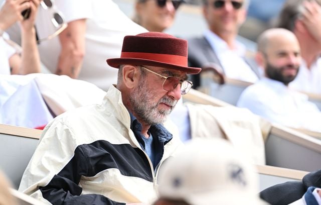 Eric Cantona se protège la tête pour éviter les coups de soleil (bien que le choix du chapeau soit discutable) lors de la finale féminine de Roland Garros 2026.