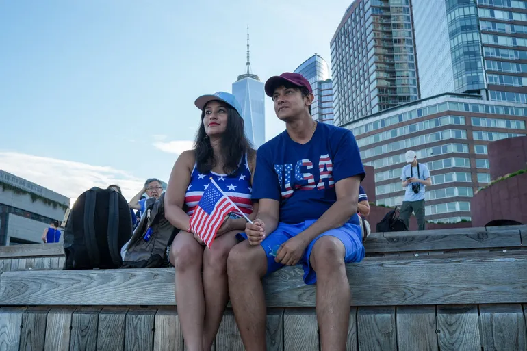 Un couple observe depuis un quai le défilé de navires « Sail4th 250 » dans le port de New York, organisé à l'occasion du 250e anniversaire des États-Unis, le jour de la Fête de l'Indépendance, le 4 juillet 2026.