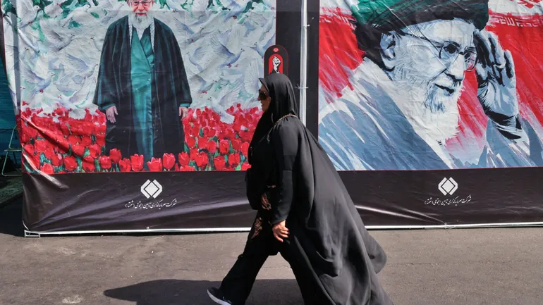 Une femme passe devant un panneau d’affichage sur lequel figure le portrait de l’ayatollah Ali Khamenei, guide suprême de l’Iran décédé, tandis que des personnes en deuil se rassemblent à la Grande Mosalla pour lui rendre un dernier hommage, au début de s